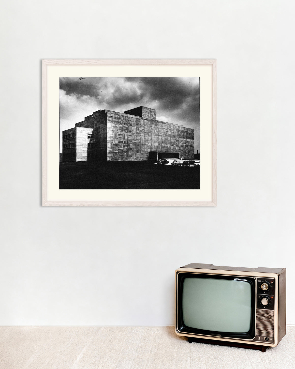 Poster «Edificio in cemento sotto la tempesta», con cornice in legno bianco